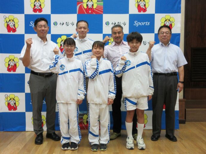 水泳の全国大会に出場する伊勢スイミングスクールの選手と市長、教育長の記念写真