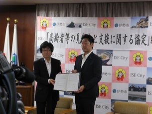 写真：協定書を手にする代表と市長