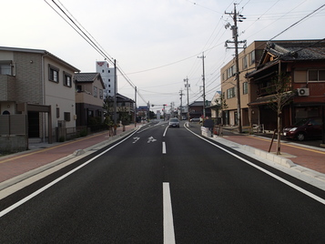 	写真：電柱が移設され車道にはセンターラインが引かれ道路両脇に歩道が整備された