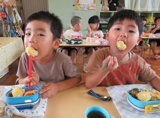 じゃがいもを食べる園児の写真