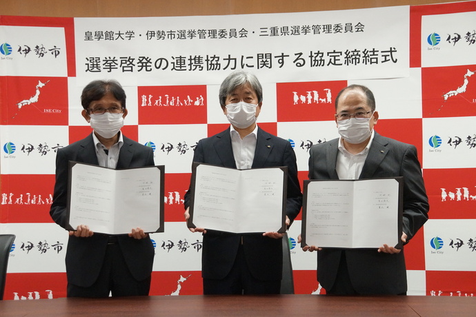 写真:調印者3人が並ぶようす