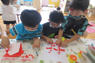 写真:玄関壁面を作る年中組さん