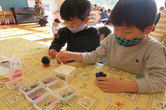 写真：松ぼっくりでクリスマスツリーを作る年長さん