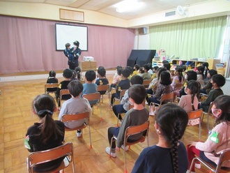 警察官の話を聞く園児の写真