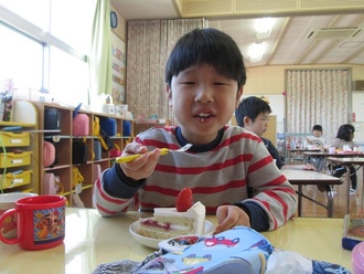 雛ケーキを食べている園児の写真