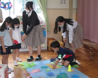 高校生と園児がすごろくをしている園児の写真2