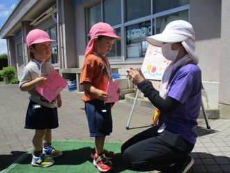 園長先生にシールを貼ってもらう園児の写真