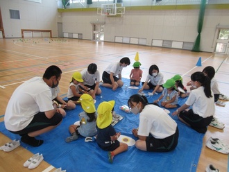 高校生と制作をする園児の写真