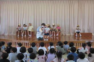 写真：園長からお祝いのカードを受け取る子ども