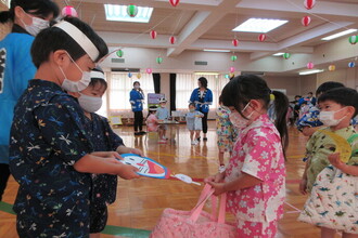 写真：お店屋さんで作品を受け取る子ども