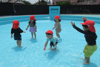 写真：プールで水遊びを楽しむ子ども達