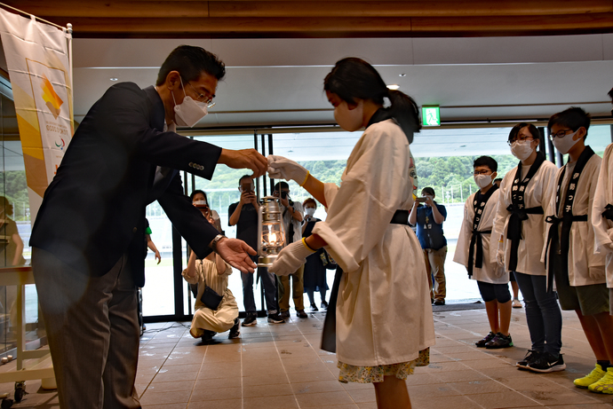 東京2020聖火フェスティバルで代表者が市長にランタンを渡している様子