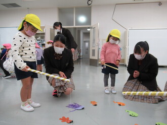 4歳児が魚釣りゲームをする園児の写真