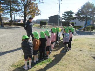 サッカー教室で講師のの話を聞く園児の写真