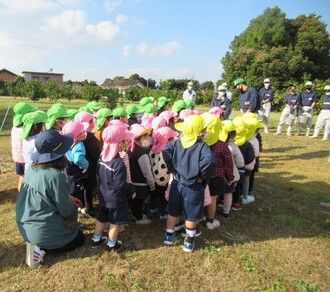 高校生の説明を聞く園児の写真