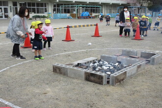 写真：たき火にいもを入れる子ども達