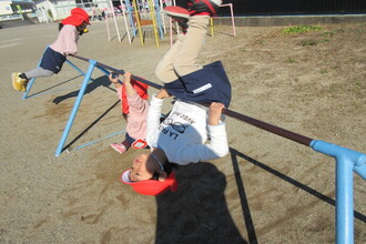 鉄棒の前回りをする子ども達