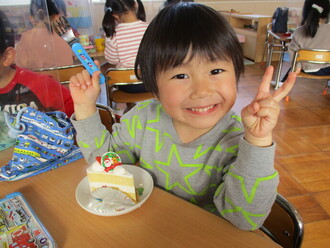 クリスマスケーキを食べる園児の写真