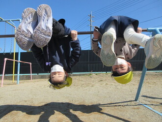 写真：鉄棒で前回りをする子ども達