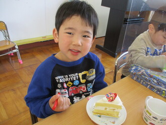 雛ケーキとカルピスを食べている園児の写真