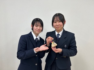 しめ縄風キーホルダー作りを紹介する高校生メンバー