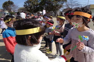 写真：手作りの花を受け取る年長児