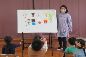 写真：パネルシアターを演じる先生　子どもたち夢中です