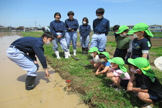 学生さんの田植えの仕方の説明を聞いている子どもたち