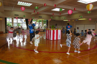 盆踊りを輪になって踊る年中組の子ども達