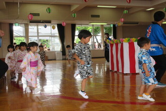 盆踊りを音楽に合わせて踊る年中組の子ども達