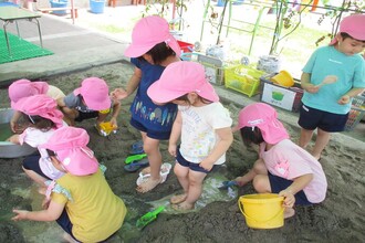 砂場で水を流しいれて川を作っています。