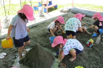 砂場で川と山をつくって遊んでいます