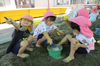 砂場で砂と水を混ぜて遊んでいます