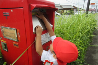 ポストに手紙を入れている年少児