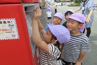 ポストに手紙を投函する年長児