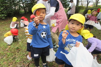 遠足で葉っぱを拾っている年少児