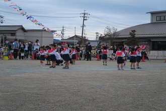 トラックの中央で円になって踊る年少組の子ども達