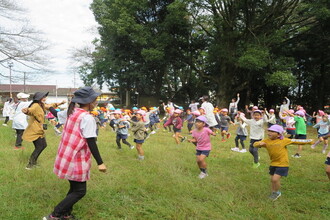 公園で体操をする職員と子ども達