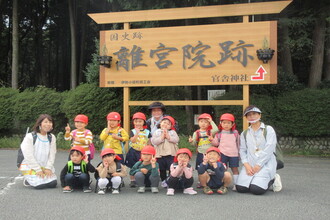 離宮院公園の看板前で集合写真を撮影してもらう年少組の子ども達