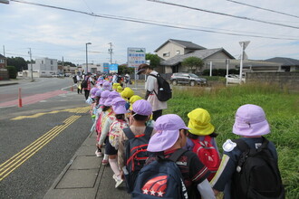 年少組の子ども達と手をつないで歩く年長組の子ども達