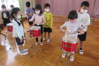 き組（4歳児）がみどり組（5歳児）鼓隊演奏を教えてもらっています
