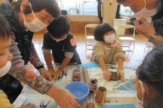 陶芸クラブの方に教えてもらいながら作品を作る年長児