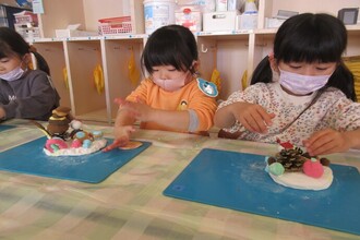 紙粘土でクリスマスケーキを作る年中組の子どもたち