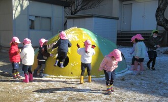 遊具に積もった雪を集めています