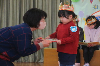 誕生日プレゼントをもらう年少児