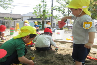 砂場で遊んでいる年少児