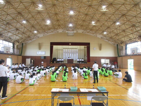 生徒会立候補者の演説を聞く生徒の写真