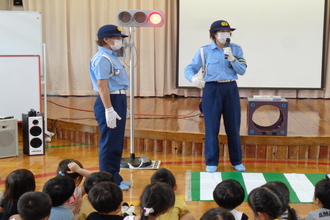 横断歩道のわたり方を教えている警察官