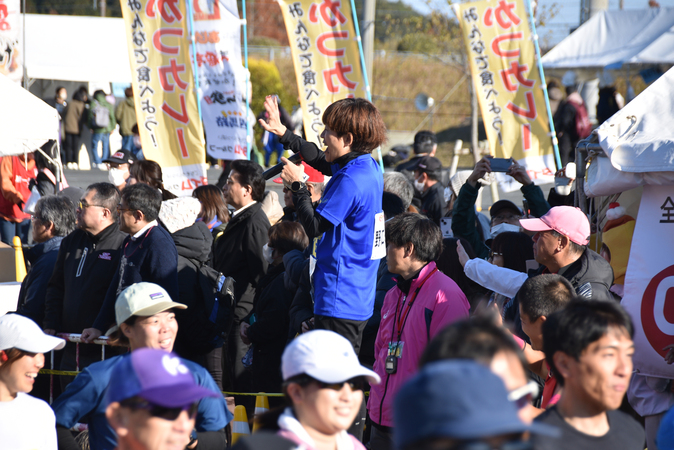 野口みずきさんがランナーに手を振っている写真