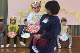 写真：園長先生に抱っこしてもらう年少児